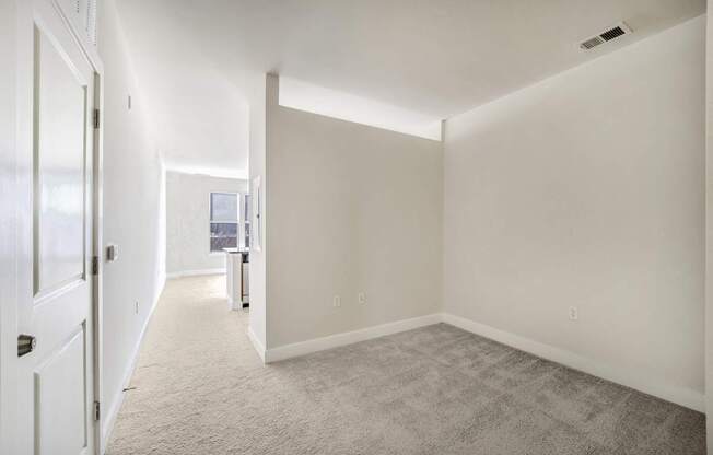 A long, empty room with carpeted floors and white walls.