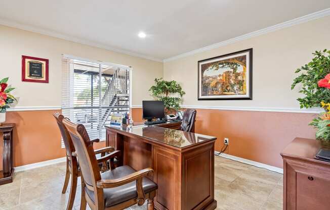 a desk with chairs in a room with a window