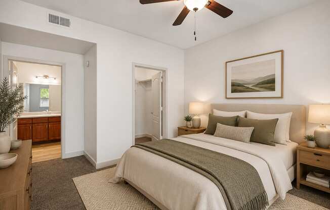 A bedroom with a large bed and a ceiling fan.