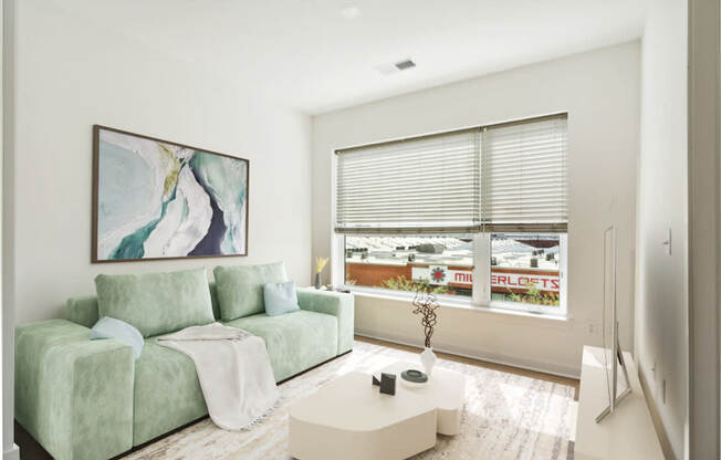 a living room with a green couch and a large window at The Box, Richmond, 23224