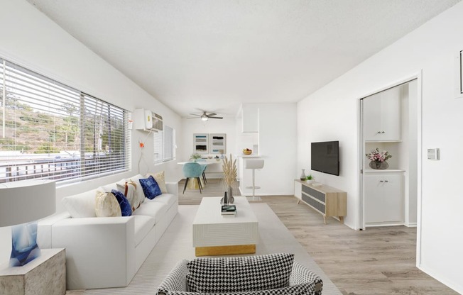 a living room with white furniture and a large window