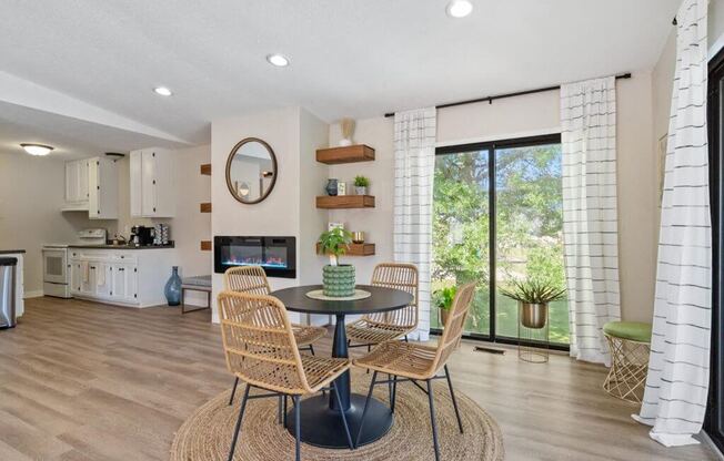 a dining room with a table and chairs in front of a window