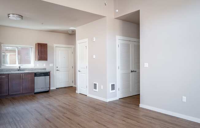 a kitchen and living room with hardwood floors and white walls