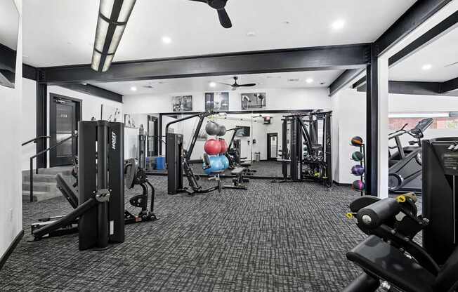 A black and white photo of a gym with a variety of equipment.