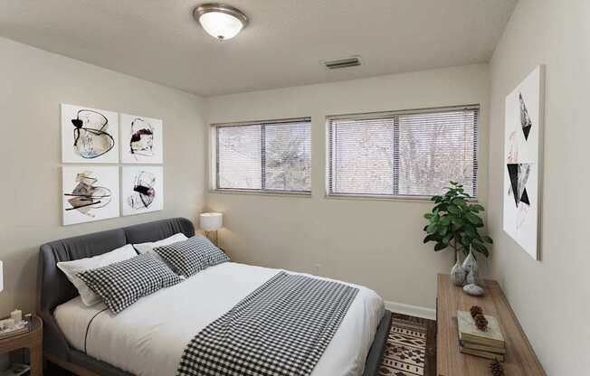 A bedroom with a bed, nightstand, and pictures on the wall.