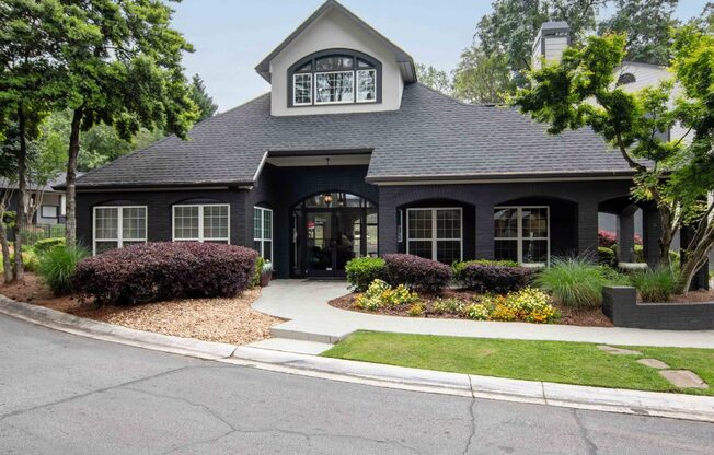 a black house with a sidewalk in front of it