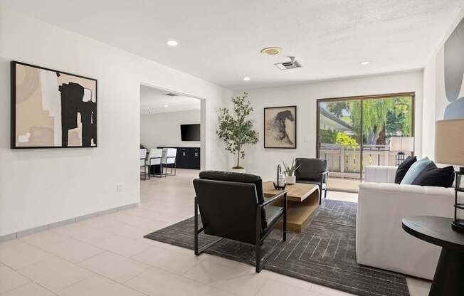 A living room with a black chair and a white couch.