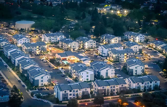 A residential area with multiple houses and street lights on.