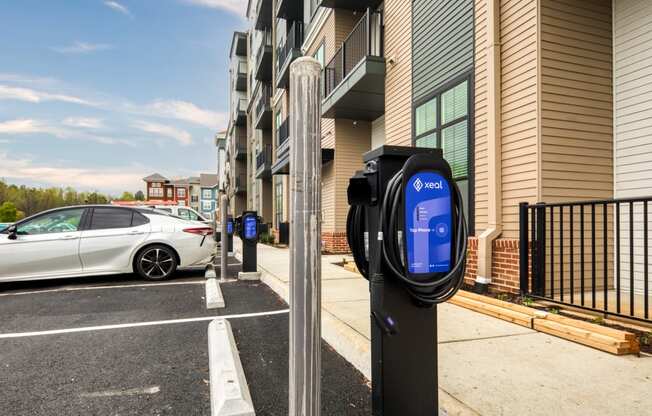 a parking meter with a white car parked in front of a building at Aura Stonebridge, Richmond, 23225