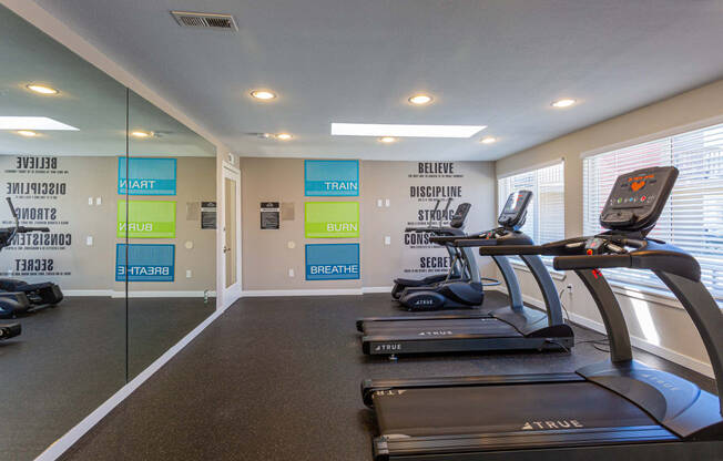 a gym with treadmills and other exercise equipment at the enclave at university crossings