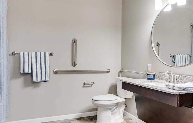 a bathroom with a toilet and a sink and a mirror. Circle Pines, MN Lexington Lofts