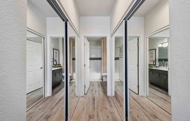 a spacious master bathroom with a hardwood flooring and white walls and ceiling. the room