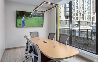 a conference room with a tv and a table with chairs