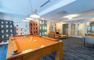 A stylish billiards room with a pool table and comfortable seating in the lounge