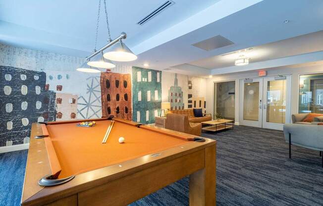 A stylish billiards room with a pool table and comfortable seating in the lounge