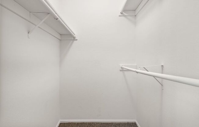 an empty white room with a white wall and a rail on the wall