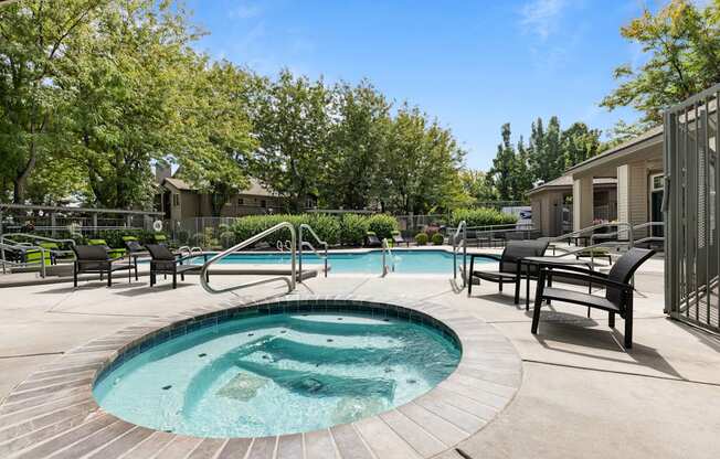 our resort style hot tub is surrounded by our patio furniture and a pool