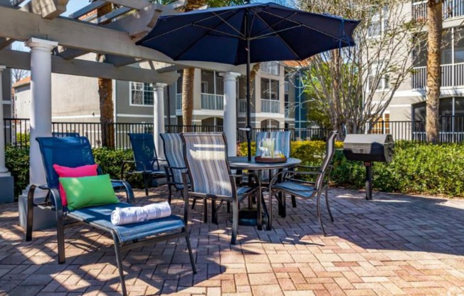 patio with a table and chairs under an umbrella at Mainstreet Apartments, Clearwater, FL