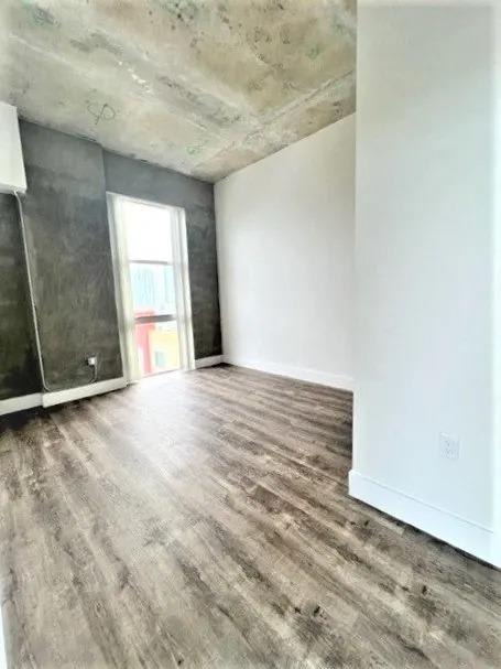 an empty room with wood floors and a closet