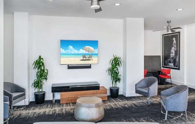 A living room with a painting of a beach scene on the wall.