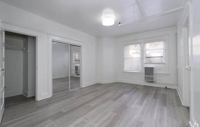 an empty living room with white walls and a mirrored closet at Clay & Tiffany, Portland, OR