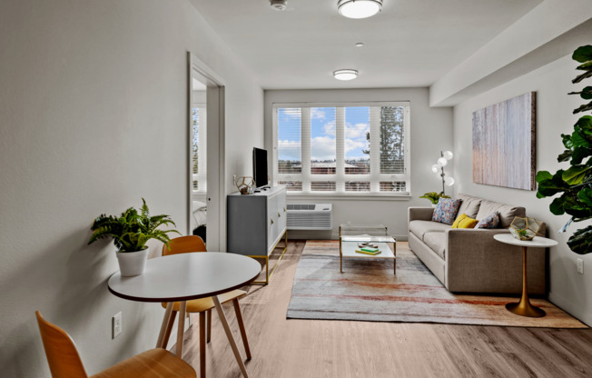 Living room and dining area with large, oversized windows at The Hixon Apartments