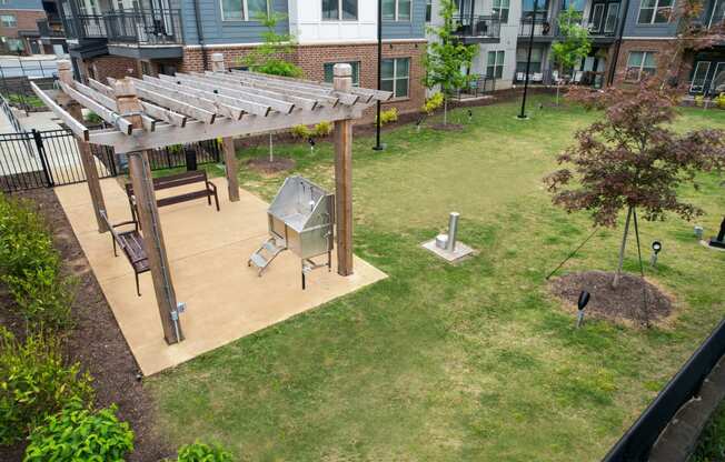 a patio with a grill and a picnic table in a backyard