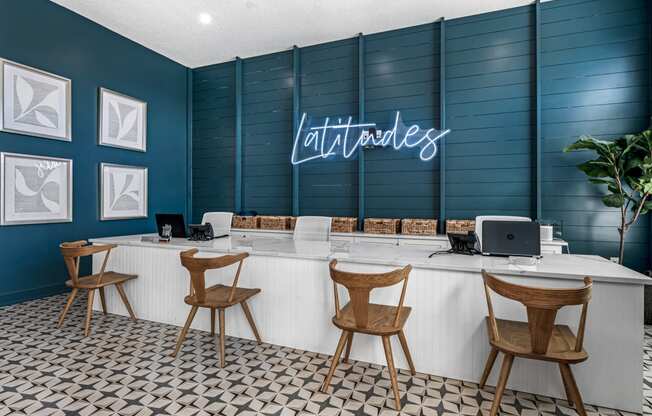 a blue and white lobby with chairs and a desk with a laptop