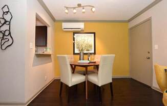 A dining room with a table and chairs.