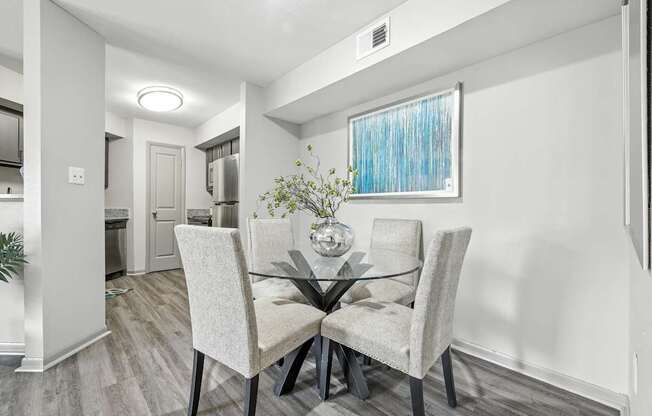 A dining room with a glass table and chairs.