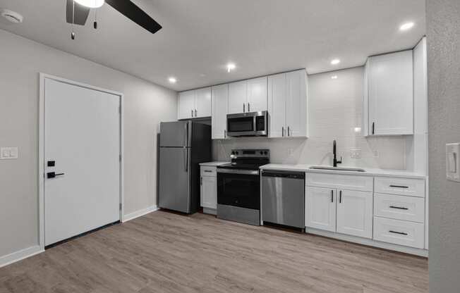 an empty kitchen with white cabinets and stainless steel appliances at Sunset Heights, Texas, 78209