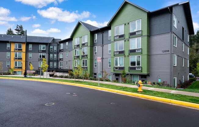 an empty street with an apartment building and a yellow fire hydrant