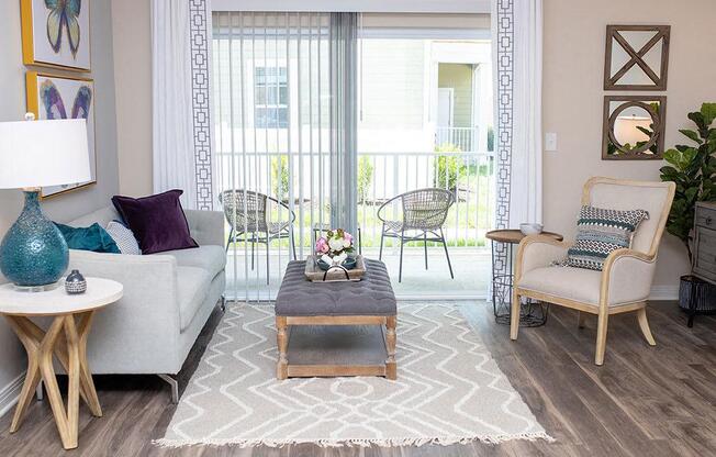 a living room filled with furniture and a large window  at Sapphire at Centerpointe, Midlothian, VA