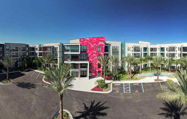 a building with palm trees in front of it at Pinnacle Apartments, Jacksonville, FL