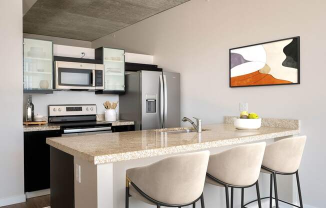 a kitchen with a marble counter top with three stools