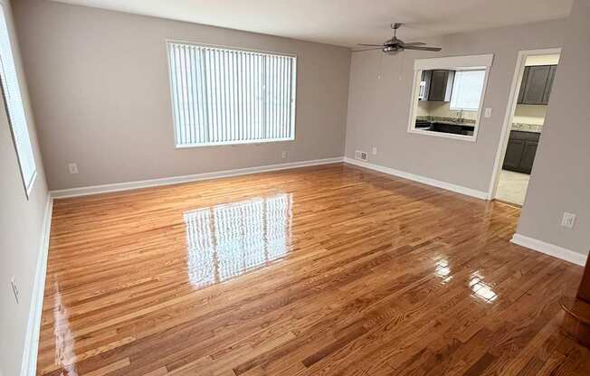 A room with wooden flooring and a ceiling fan.