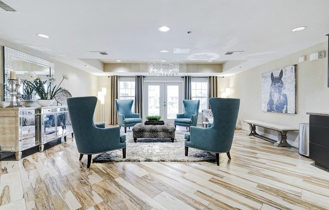 a living room with blue chairs and a rug