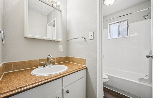 Bathroom featuring a modern sink, elegant mirror, and ample natural light
