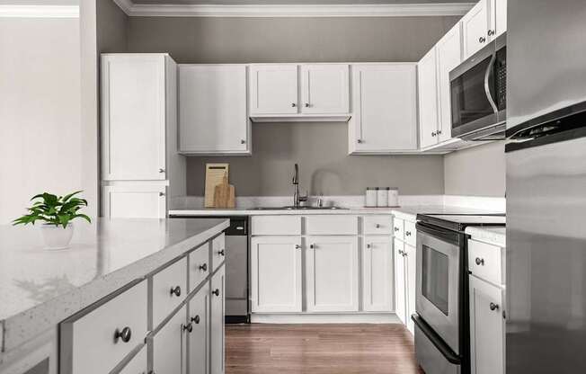 A kitchen with white cabinets and appliances.