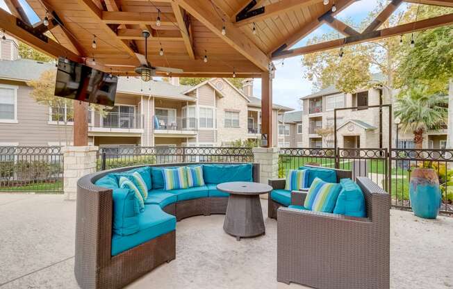 a covered patio with couches and a table
