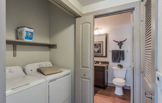 a bathroom with a washer and dryer and a toilet