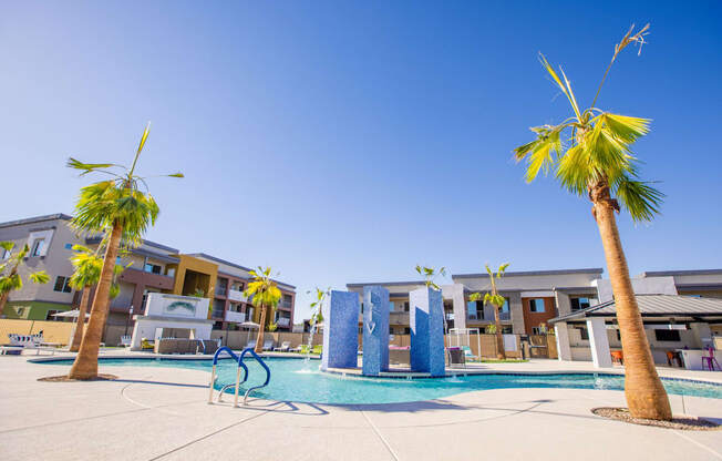 a swimming pool with palm trees and apartments in the background