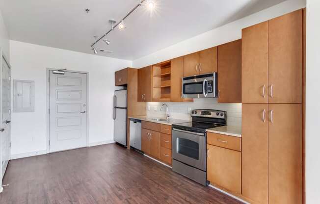 Pet Friendly Apartments in Nashville, TN - 12 South Apartments - Kitchen area with cabinet space, stainless steel appliances, open concept wood-style flooring.