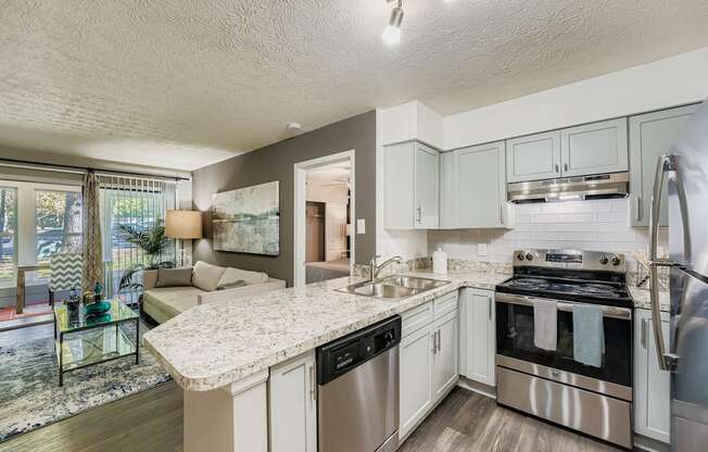 A modern kitchen with stainless steel appliances and a marble countertop.