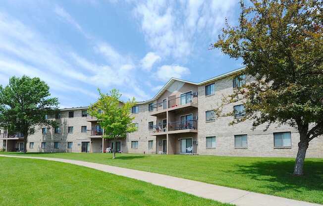 A large apartment complex with a green lawn in front.