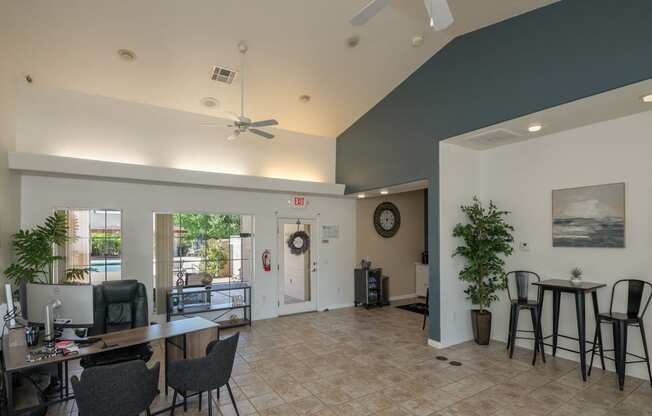 a living room with a table and chairs and a ceiling fan