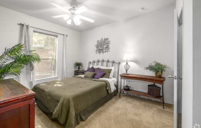 a bedroom with a bed and a ceiling fan