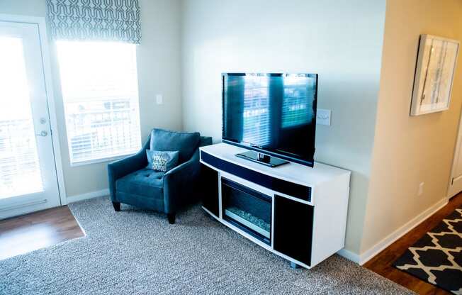 a living room with a large tv and a chair