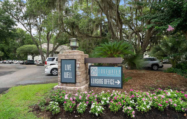A sign for 29 Eggwater Leasing Office is in front of a flower bed.