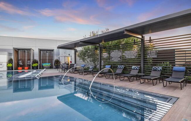 a swimming pool with lounge chairs and a roofed pool